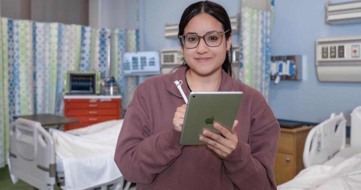 Nursing student examining patient records on iPad