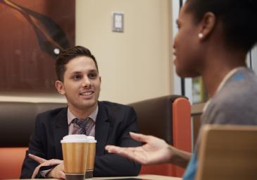 two business students conversing in dunkin donuts