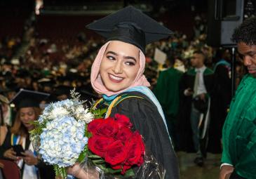 Student at graduation with flowers