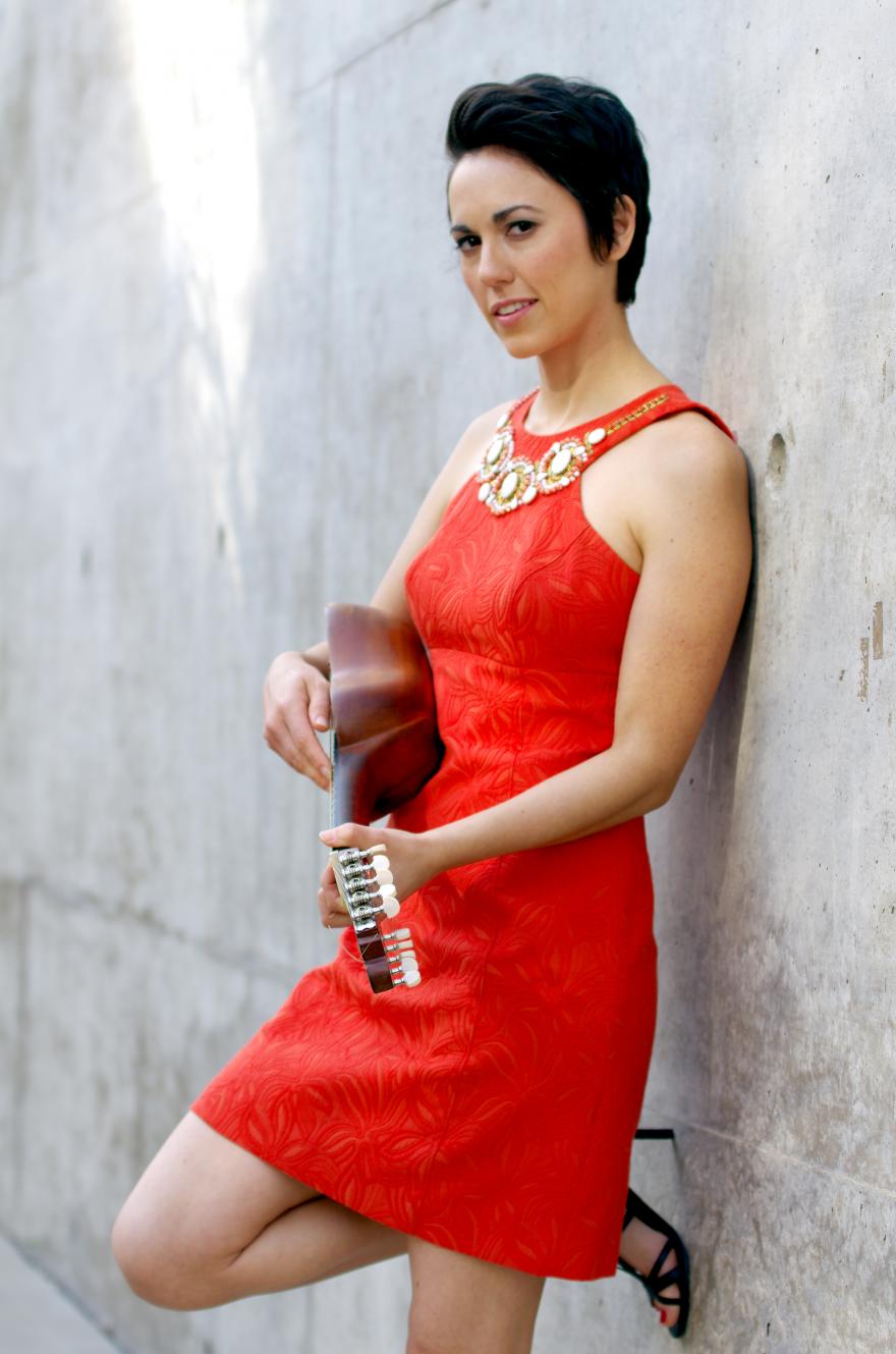 Gina Chavez in red dress holding string instrument