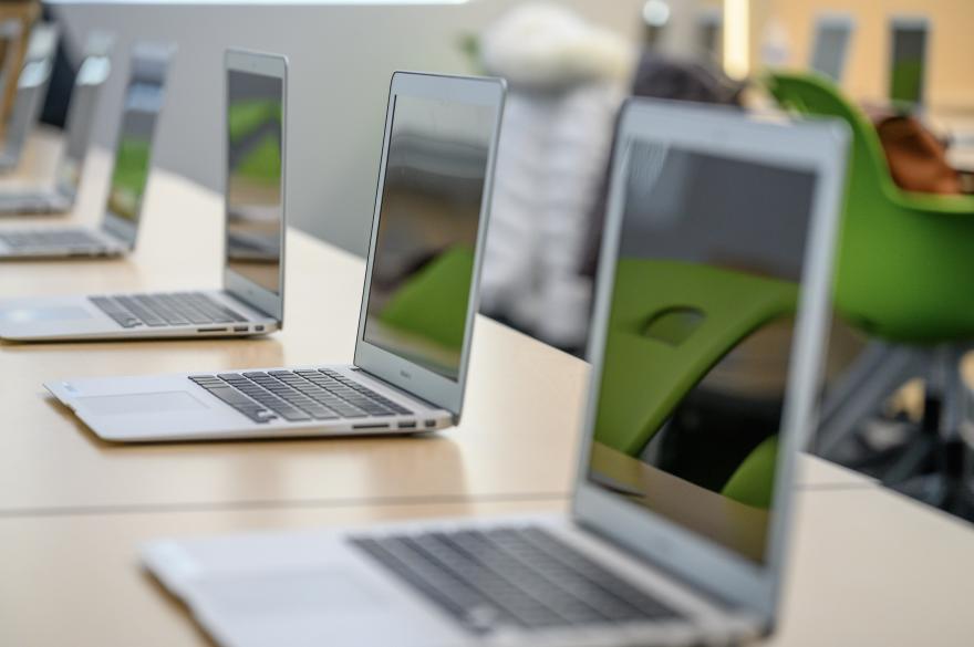 Row of MacBooks on tables in Nursing classroom