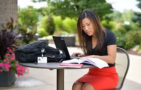 Student sitting with laptop and textbook