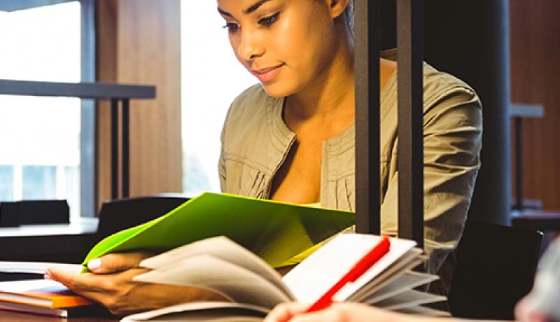 student reading coursework at a desk