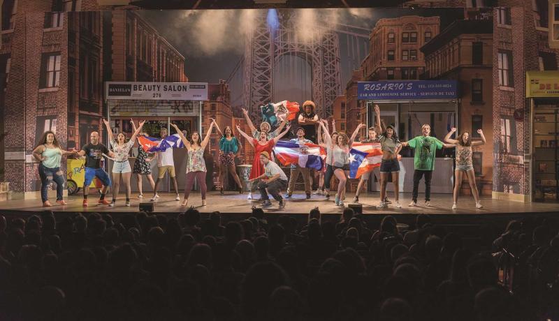 Cast of "In the Heights" singing on stage.