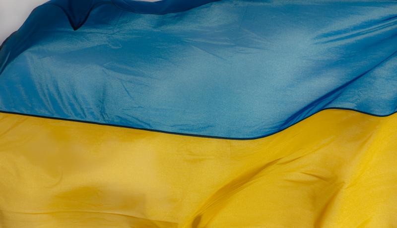 Ukraine flag waving on the wind against the blue sky GettyImages-1347676579
