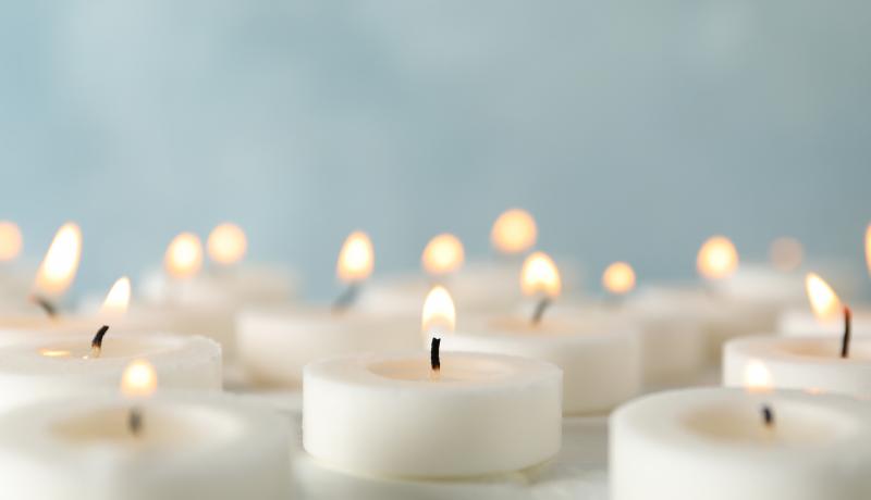 Group of burning candles against blue background, close up - stock photo GettyImages-1195555709