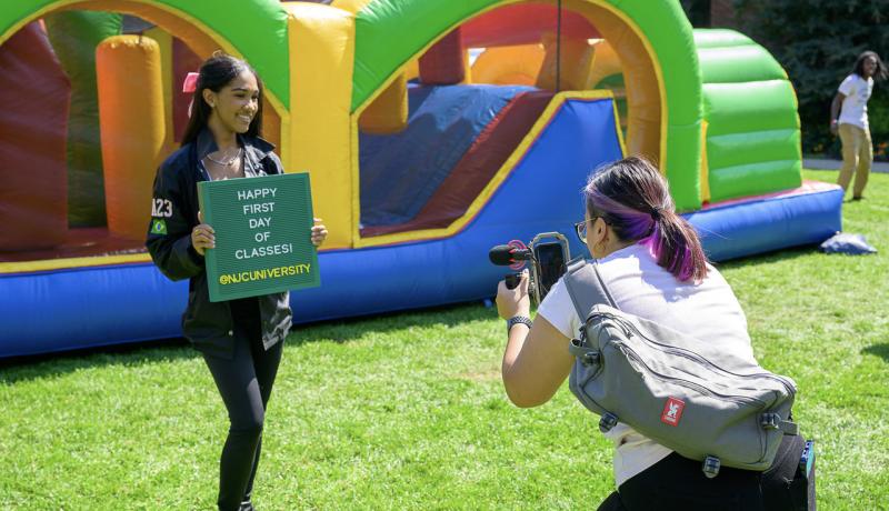 Student holding Happy First Day of Classes sign
