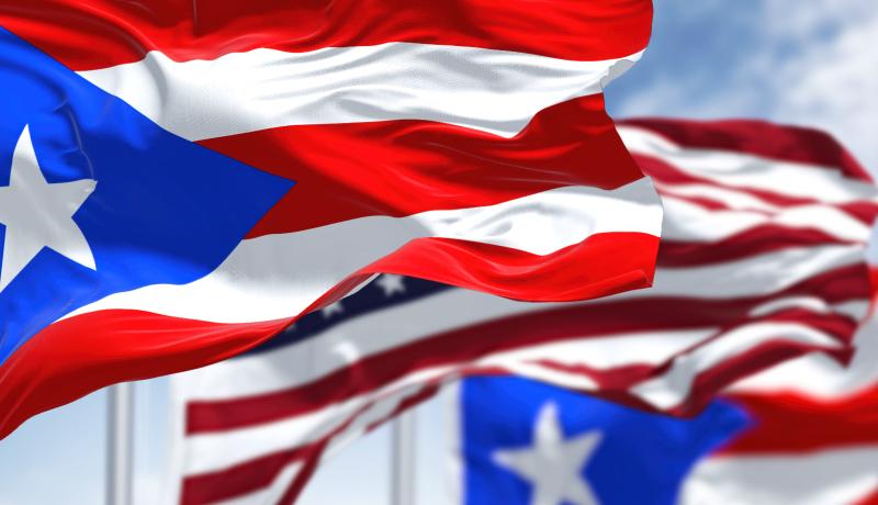 Flags of Puerto Rico waving alongside the USA flag