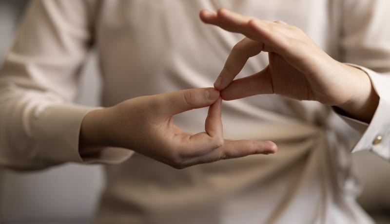 Woman using sign language - stock photo GettyImages-1960781418