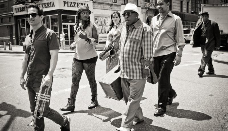 The Gabriel Alegria Afro-Peruvian Sextet, jazz sextet walking with their instruments on a city street