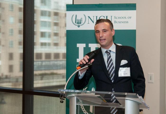 David Weiss, Esq., director of the NJCU School of Business Institute for Dispute Resolution, standing at a podium in the Skyline Room of the School of Business