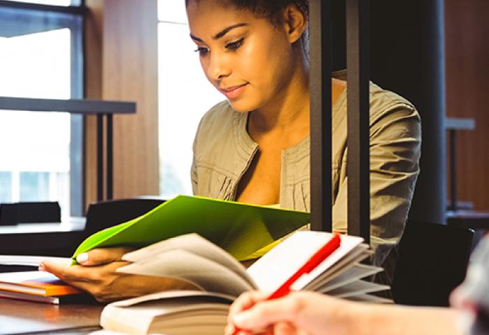 student reading coursework at a desk