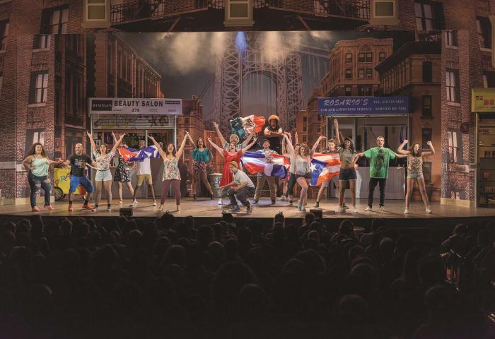 Cast of "In the Heights" singing on stage.