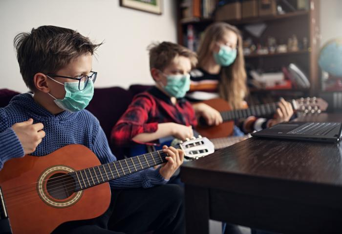 Brother and sister playing guitars together - stock photo GettyImages-1214130327