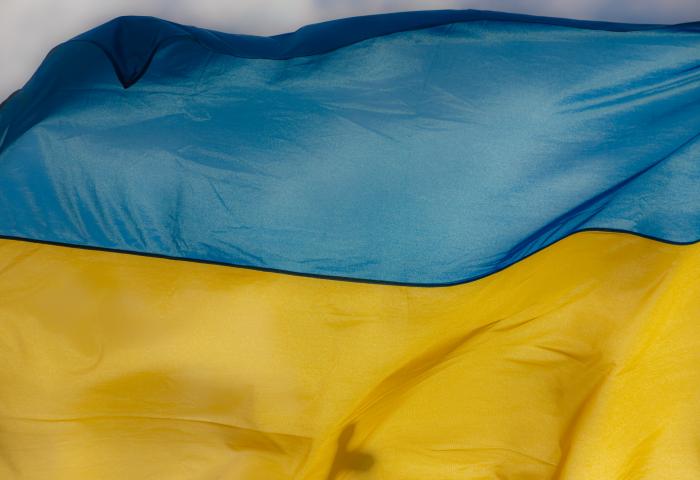 Ukraine flag waving on the wind against the blue sky GettyImages-1347676579