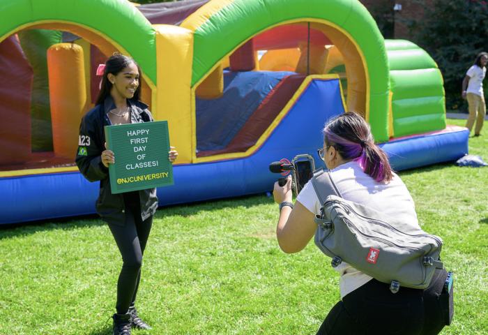 Student holding Happy First Day of Classes sign