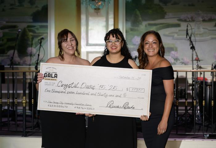 Alumna Crystal Davis receives a check from Nadia Tini and Cinthia Diaz at the NJCU Gala