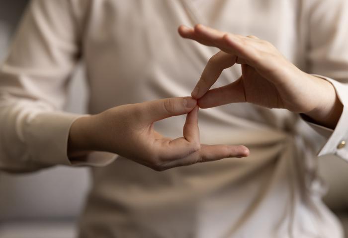Woman using sign language - stock photo GettyImages-1960781418