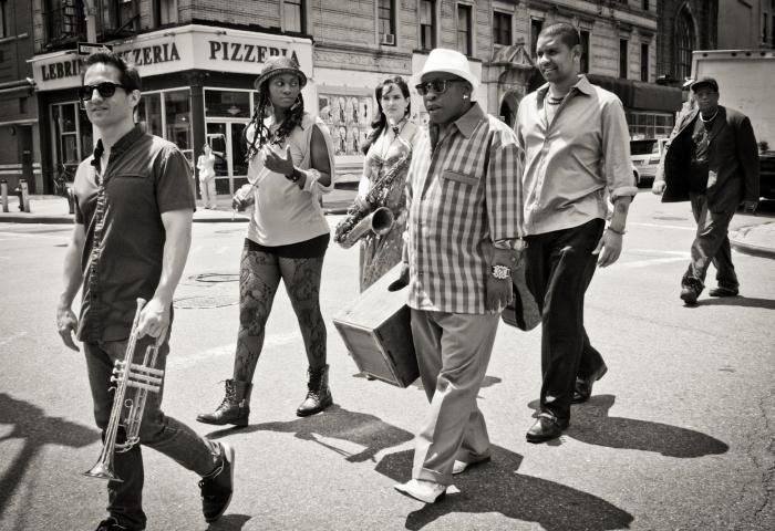The Gabriel Alegria Afro-Peruvian Sextet, jazz sextet walking with their instruments on a city street