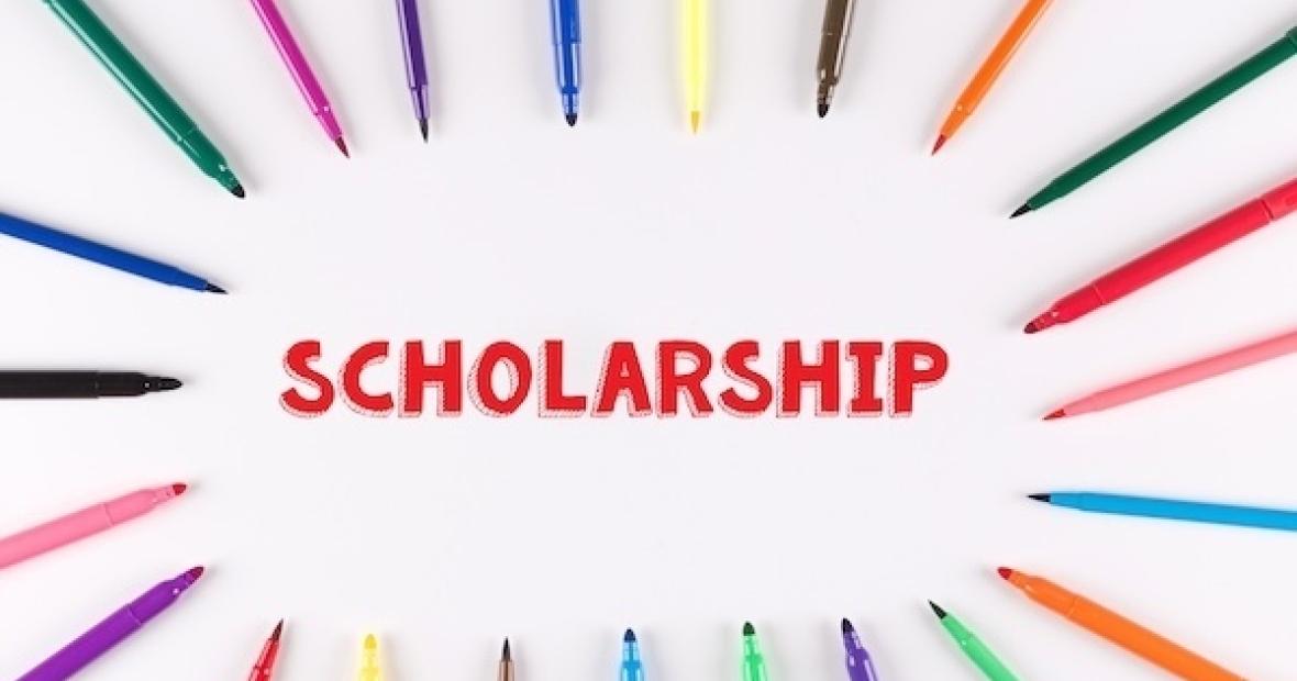 The word Scholarship encircled by an assortment of writing tools.