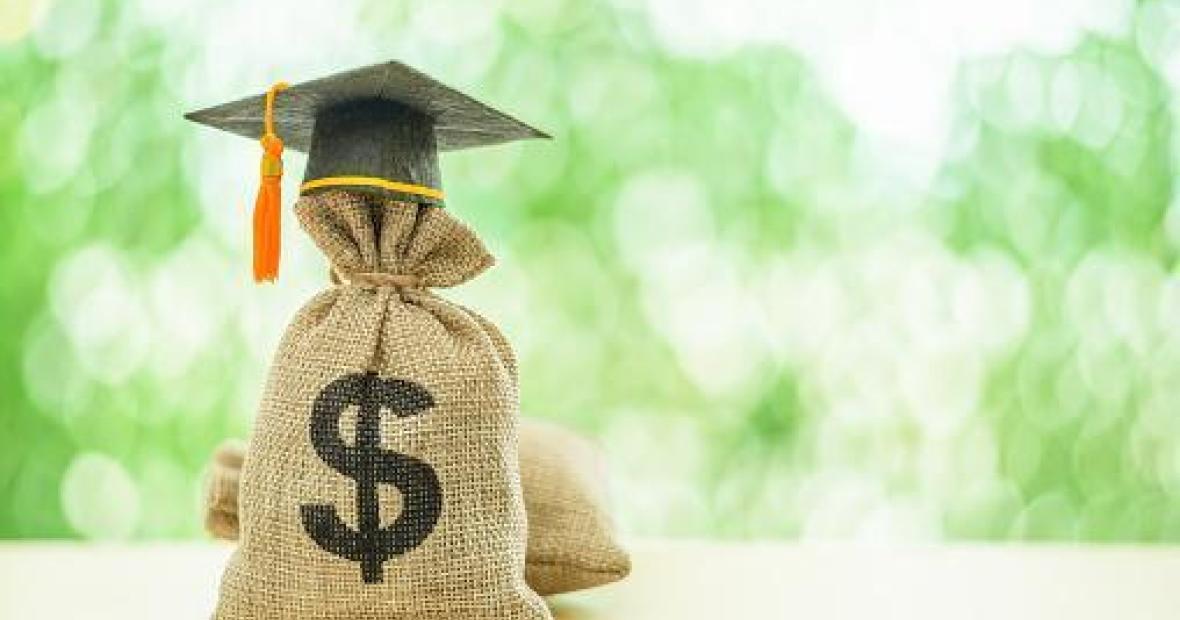 A sack with a dollar sign on it and topped with a graduation cap.