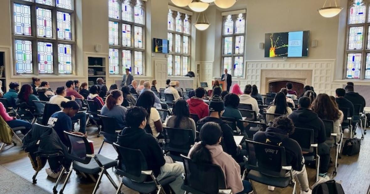 speaker at podium, atendees seated