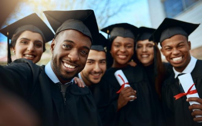 SIX BLACK STUDENTS IN GRADUATION ATTIRE SMILE