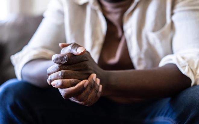 black seated male clasped hands