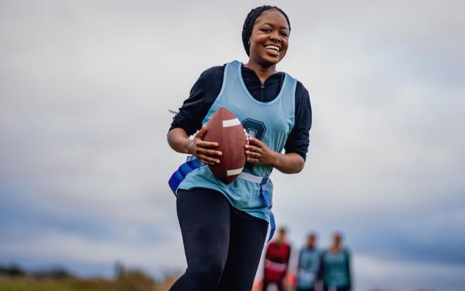 WOMAN RUNNING WITH FOOTBALL