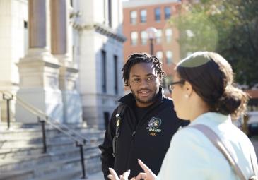 male and female student talking in front of city hall downtown jersey city