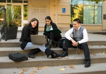 students sitting in front of the library