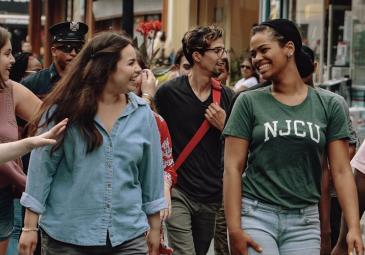 Image of NJCU students smiling at each other 