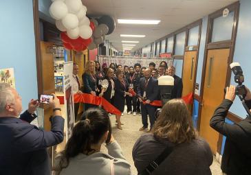 people in hall cutting a ribbon