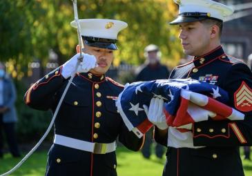 2 millitary students rasing flag