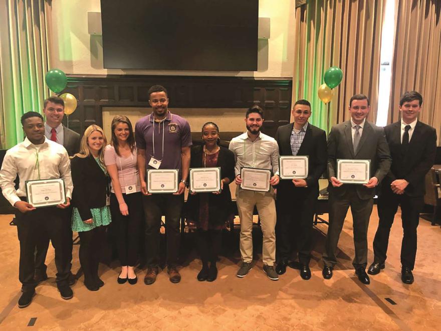 NJCU students posing after induction into Omicron Sigma Sigma.