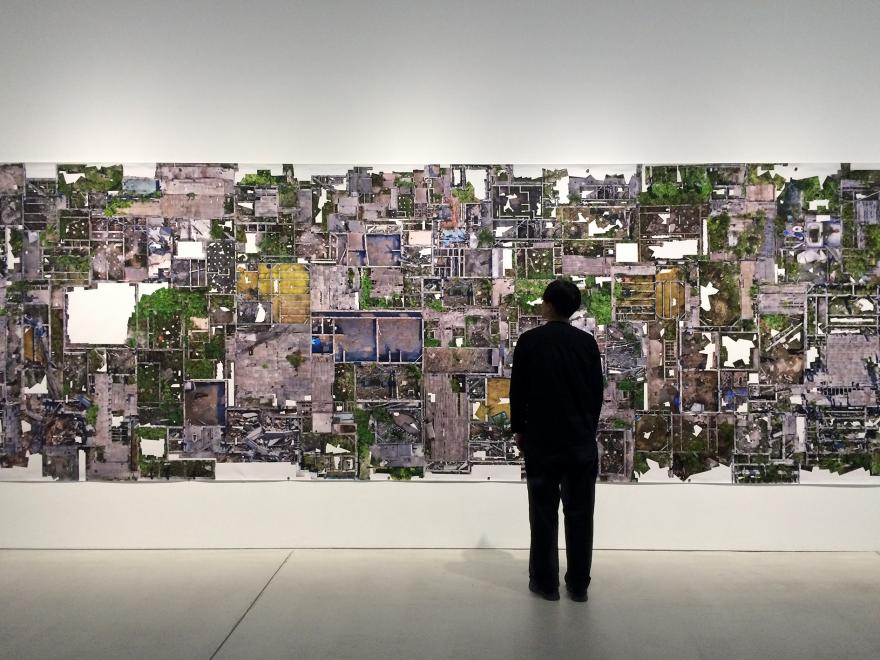 Person looking at an image in an exhibit showing a top view of an area.