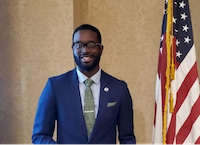 IKE EJIKEME HEADSHOT WITH USA FLAG