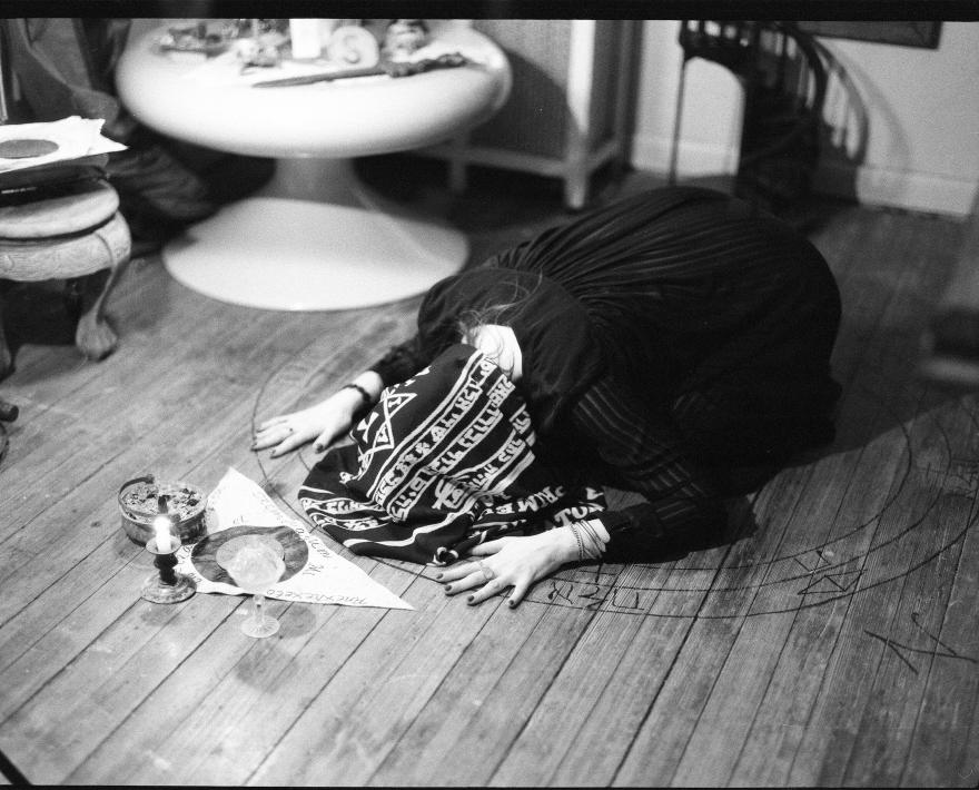 A woman bent on the floor in prayer
