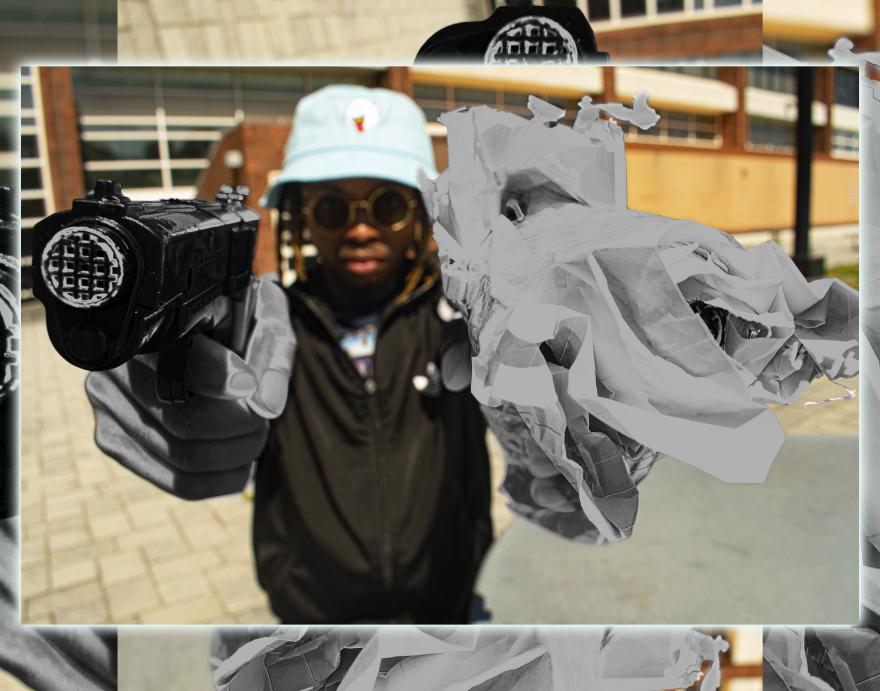 Person in shades holds a gun to the camera