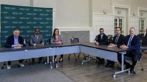 6 people seated and facing camera