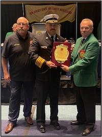 FIREMAN AND 2 MEN POSE WITH PLAQUE