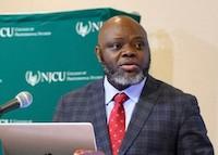 man at podium looks away