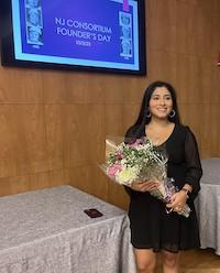 WOMAN STANDS WITH FLOWERS