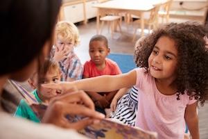 CHILDREN IN CLASSROOM LOOK TOWARD TEACHER