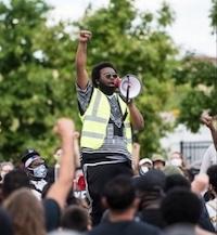 Nevin Perkins in crowd, fist up