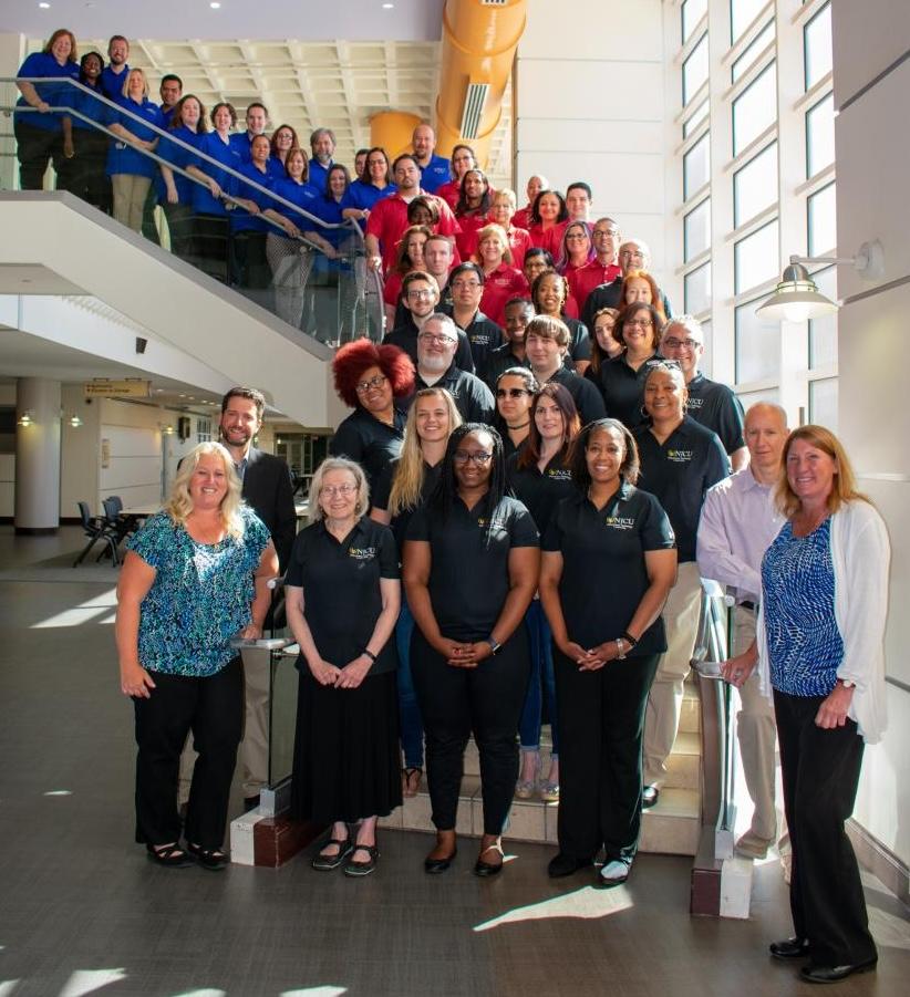 cohorts and faculty pose on stairs