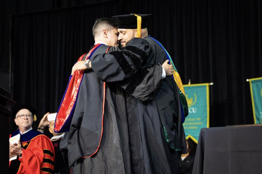 President Acebo embraces Suraj Kaufman, Presidential Medallion recipient.