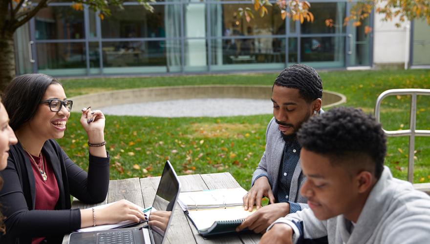 NJCU Open House students smiling at a table.