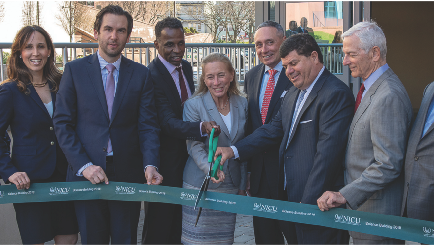 Several people cutting the ribbon to open the newly renovated Science Building.