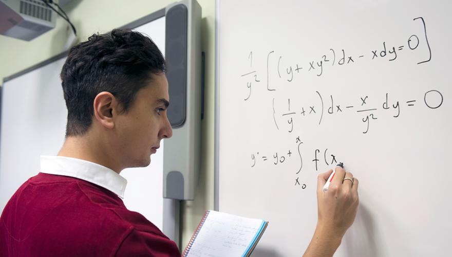 math student working on an equation on a whiteboard